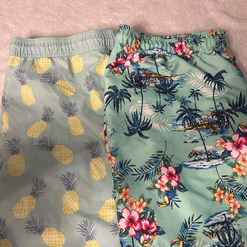 2 pairs of Tropical Print adult swimming trunks.